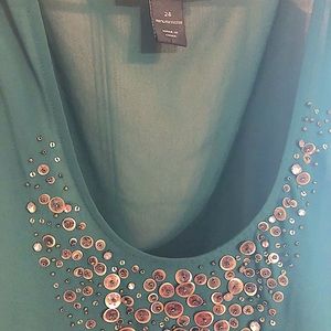 Sleeveless, flowy top, emerald green with eye catching accent.